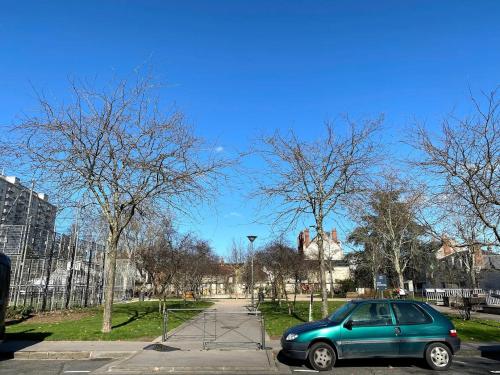 a small green car parked in a parking lot at Appartement charmant proche Gare in Tours