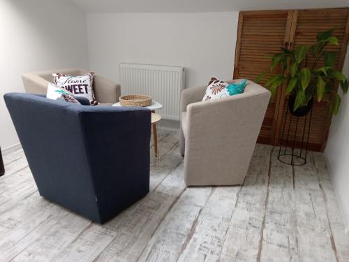 two chairs and a table in a living room at La Maia Acasă - Refugiul boem in Sibiu