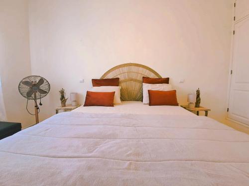 a large white bed in a room with a fan at Apartamento Oásis Parque 2 in Portimão
