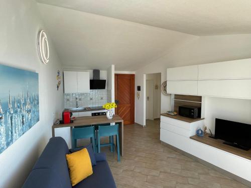 ein Wohnzimmer mit einer blauen Couch und einer Küche in der Unterkunft The Seaside Serenity Terrace in Giardini-Naxos