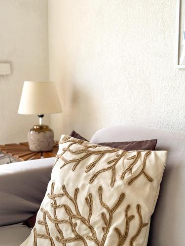 - un oreiller sur un lit avec une table et une lampe dans l'établissement Coquet Appartement Avec Le Terrasse Sur Le Mer, à Roquebrune-Cap-Martin