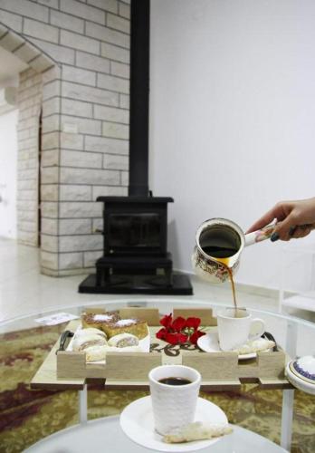 a person is pouring coffee into cups on a table at אחוזות החרמון in Mas'ade