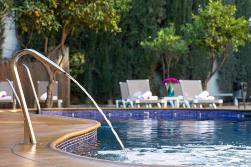 a pool with a water hose in the middle of it at Hotel Plaza Del Castillo in Málaga