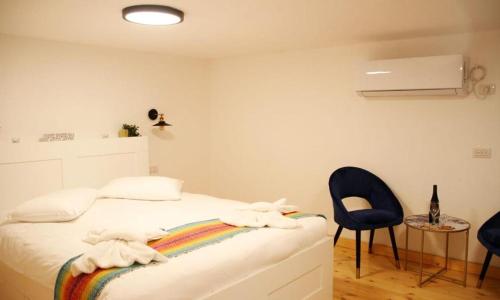 a bedroom with a bed with a rainbow blanket and a chair at אחוזות החרמון in Mas'ade