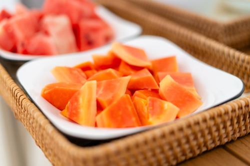 two white plates of cut up fruit on a table at Madi Maldives Ukulhas in Ukulhas