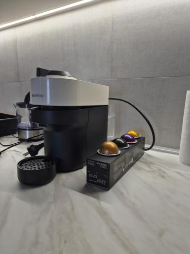 a coffee maker and a box of donuts on a counter at Knezev Park Apartment in Novi Sad