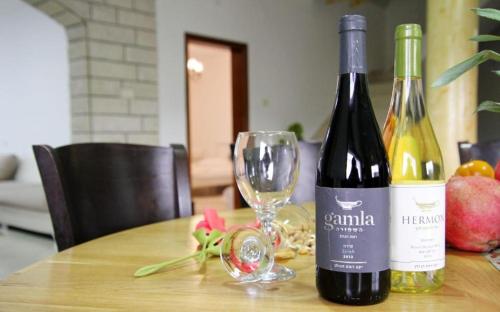 a bottle of wine and a glass on a table at אחוזות החרמון in Mas'ade