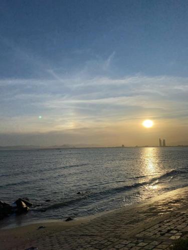 a sunset on the beach with the sun setting at Hoa Nắng homestay in Ninh Hải