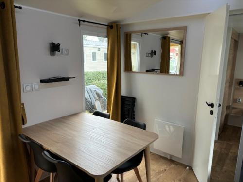 une salle à manger avec une table, des chaises et un miroir dans l'établissement Amira 6-8 personnes, à Saint-Jean-de-Monts