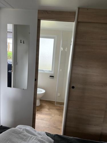 - une chambre avec un miroir et une salle de bains avec des toilettes dans l'établissement Amira 6-8 personnes, à Saint-Jean-de-Monts