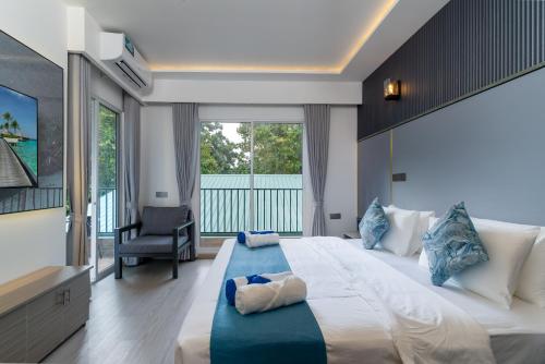 a large bedroom with a large bed and a balcony at Madi Maldives Ukulhas in Ukulhas