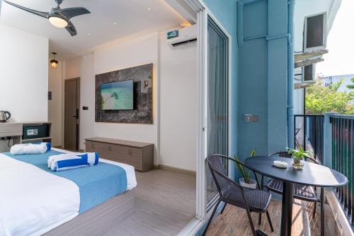 a bedroom with a bed and a table on a balcony at Madi Maldives Ukulhas in Ukulhas