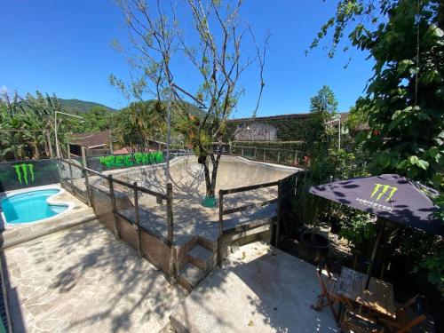 a patio with a pool and an umbrella at Tree Park Cambury in Camburi