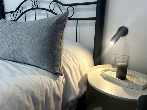 a bed with a pillow and a table with a lamp at Apartamento de ensueño, vistas al bosque, Stevier in Icod de los Vinos