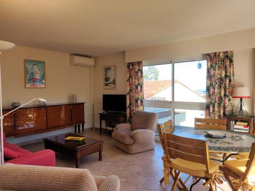 un salon avec un canapé, une table et une télévision dans l'établissement Appartement ORION magnifique vue mer et montagne, à Mandelieu-la-Napoule