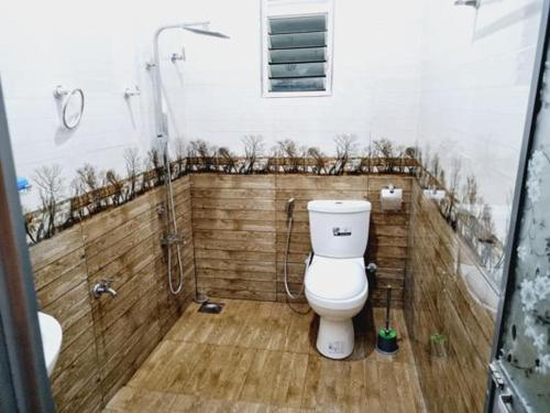 a bathroom with a white toilet and a shower at HANSI Villa in Piliyandala