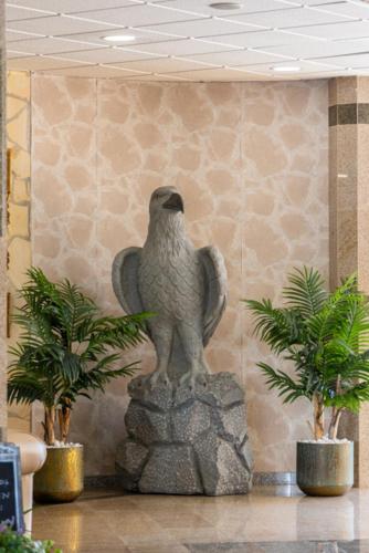 a bird statue in a lobby with two plants at Hotel Plaza Del Castillo in Málaga