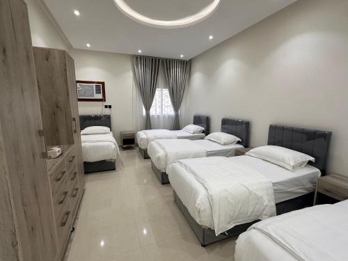 een slaapkamer met 4 bedden in een kamer met een plafond bij شقق مفروشة 22 in Al Madinah