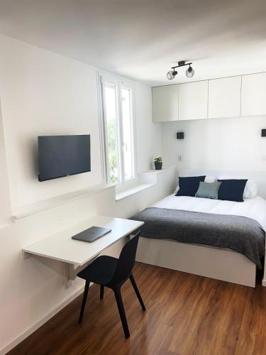 une chambre avec un lit, un bureau et une télévision dans l'établissement Hono - Studio en plein coeur du centre ville, à Dax