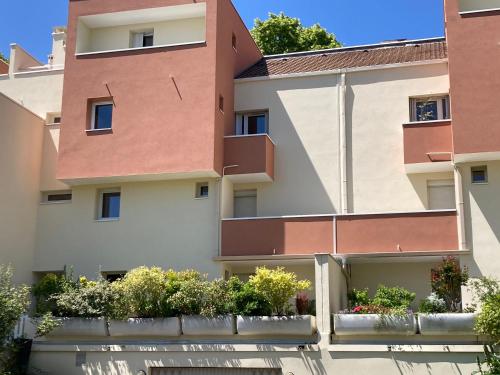 un immeuble d'appartements avec des plantes devant lui dans l'établissement CHAMBRE CHEZ L'HABITANT NOISIEL, à Noisiel