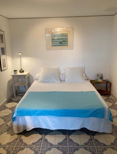 une chambre avec un grand lit avec une couverture bleue dans l'établissement Studio Les PIEDS DANS L'EAU, à Portiragnes