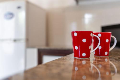 two red cups sitting on top of a counter at Casa en el Casco Historico con Vista al Rio in Colonia del Sacramento