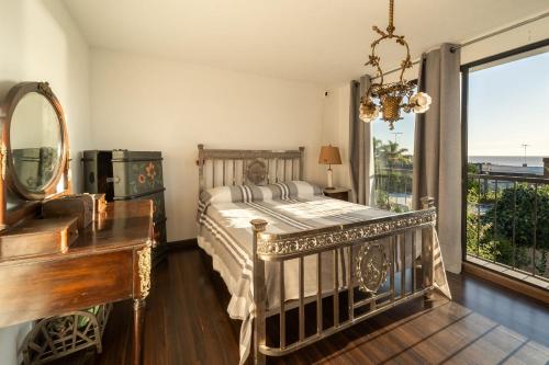 a bedroom with a bed and a piano and a mirror at Casa en el Casco Historico con Vista al Rio in Colonia del Sacramento