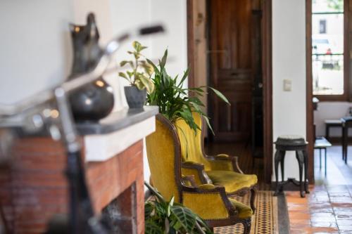 a living room with yellow chairs and a fireplace at Casa en el Casco Historico con Vista al Rio in Colonia del Sacramento