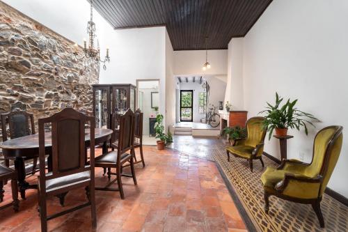 a dining room with a table and chairs and a stone wall at Casa en el Casco Historico con Vista al Rio in Colonia del Sacramento