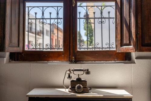 an old generator sitting on a counter under a window at Casa en el Casco Historico con Vista al Rio in Colonia del Sacramento