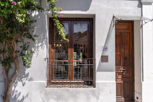 a white building with a door and a balcony at Casa en el Casco Historico con Vista al Rio in Colonia del Sacramento