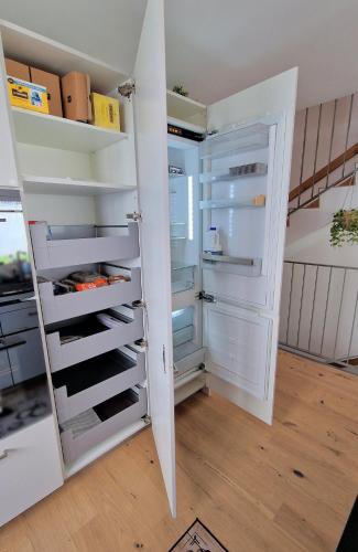 a white refrigerator with its door open in a room at Mountainside Homestay in Spiez by Menbergs Harmony Homestay in Spiez