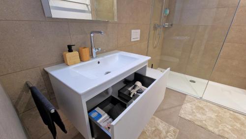 a bathroom with a white sink and a shower at Mountainside Homestay in Spiez by Menbergs Harmony Homestay in Spiez