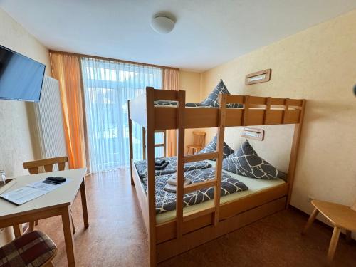 two bunk beds in a small room with a table at Pension Hönel-Hof Bad Schandau in Bad Schandau
