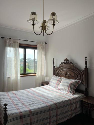 a bedroom with a bed with a plaid blanket and a window at Lovely 2 bedroom apartment 100m from the beach in Vila do Conde