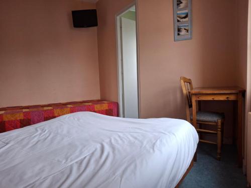 a bedroom with a bed and a chair and a desk at Hôtel de Vendée Restaurant Les2M in Fontenay-le-Comte