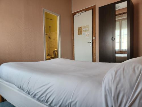 a bedroom with a white bed and a mirror at Hôtel de Vendée Restaurant Les2M in Fontenay-le-Comte