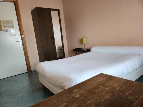 a hotel room with two beds and a table at Hôtel de Vendée Restaurant Les2M in Fontenay-le-Comte