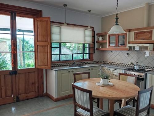uma cozinha com uma mesa de madeira e algumas janelas em Socaire, tu refugio en Chascomús em Chascomús