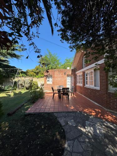 a patio with a table and chairs in front of a brick building at Chalet Mar del Plata in Mar del Plata