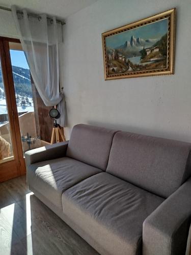 un salon avec un canapé et un tableau au mur dans l'établissement Appartement face aux pistes, à Gréolières-les-Neiges