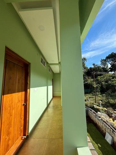 a hallway of a house with a wooden door at The Valley Rose Farmstay in Yercaud