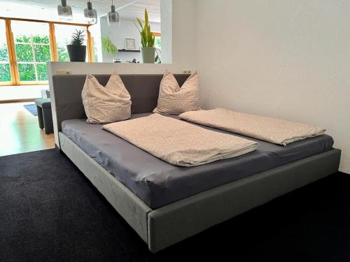 ein Bett mit zwei Kissen darauf in einem Zimmer in der Unterkunft Das Vogelnest in Rettenberg