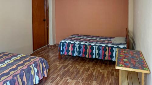 a room with two beds and a wooden floor at Aventura Chachapoyas Backpackers in Chachapoyas