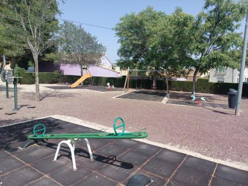 un parque infantil con una patineta verde en el suelo en CASA TURQUESA, en Torrealvilla