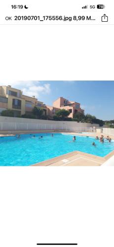 une photo d'une piscine avec des gens qui y vivent dans l'établissement Wallis2, à Sausset-les-Pins