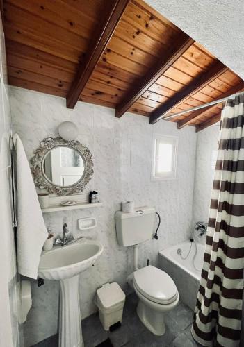 a bathroom with a sink and a toilet and a mirror at The Lovely Gem in Skopelos Town