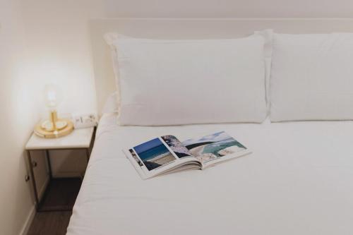 a book sitting on top of a bed at appartamento lussuoso sul porto di Cagliari in Cagliari