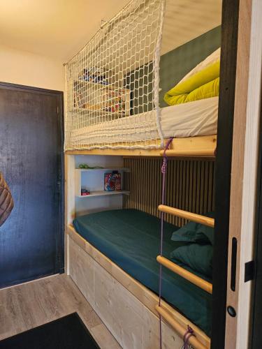 Cette chambre dispose de lits superposés et d'un chien dans une cage. dans l'établissement Appartement à la montagne, à Les Deux Alpes