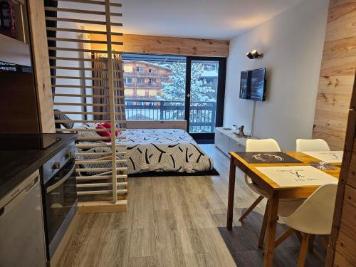 une chambre avec un lit et une table avec des chaises dans l'établissement Appartement à la montagne, à Les Deux Alpes